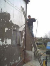 Power Washing the old loose material from the outside of a property.